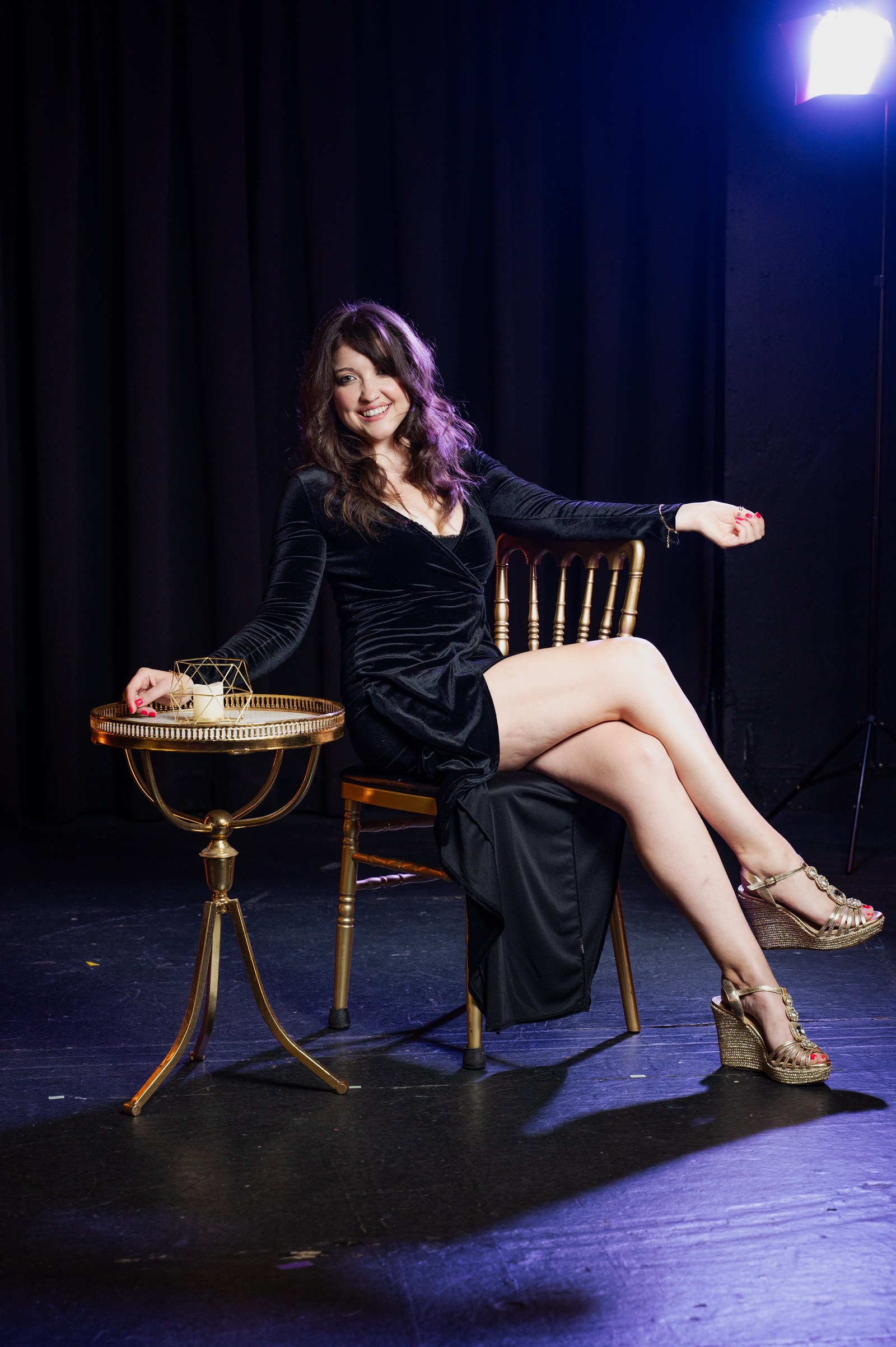 Courtney Thompson seated on a gold chair beside a gold table
